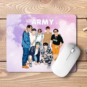 Può includere: Un tappetino per mouse rettangolare con la scritta "ARMY" in bianco e un'illustrazione a cartoni animati di sette persone. Il tappetino è su una superficie di legno accanto a un mouse bianco, una fotocamera e altre forniture per ufficio.