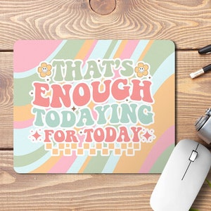 Peut inclure: Un tapis de souris rose et bleu avec un design rétro composé de lignes ondulées et un message qui dit "That's Enough Todaying For Today".