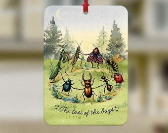 May include: A rectangular hanging air freshener featuring a whimsical illustration of various insects holding hands in a circle on a grassy field. The scene includes a praying mantis, grasshopper, moth, bee, ladybug, ant, and beetle under a crescent moon.