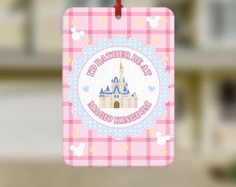 May include: A rectangular hanging air freshener featuring a pink and white plaid pattern with small white mouse head silhouettes and yellow stars. A central circular scalloped label displays a castle illustration and the text I'D RATHER BE AT MAGIC KINGDOM.