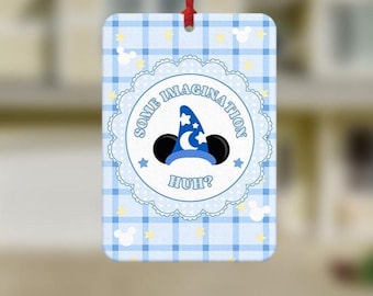 May include: A rectangular hanging air freshener featuring a light blue and white plaid pattern with small yellow stars and white mouse head silhouettes. The center displays a blue wizard hat with a white moon and stars, and the text SOME IMAGINATION HUH?