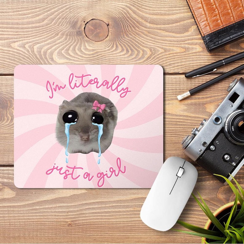 May include: Pink and white mouse pad with a cartoon hamster with big eyes and pink bow, crying with blue tears. The text "I'm literally just a girl" is written in white on the mouse pad.