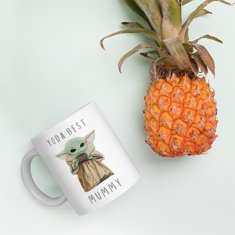 May include: White ceramic mug with a green character holding a cup, the text "YODA BEST MUMMY" is printed on the mug.