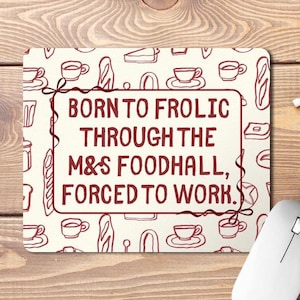 May include: A rectangular mouse pad with a cream background and a repeating pattern of dark red line drawings of food and drink items. The centre features a dark red rectangular border containing the text: BORN TO FROLIC THROUGH THE M&S FOODHALL, FORCED TO WORK.