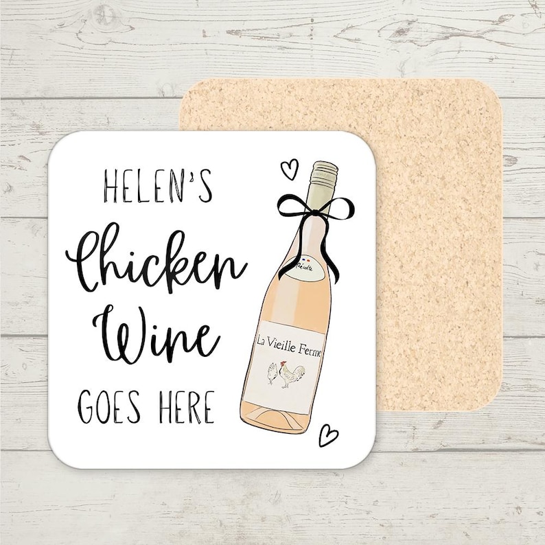 Op de afbeelding: Een vierkante witte onderzetter met de tekst "Helen's Chicken Wine GOES HERE" in zwart schrift. Een illustratie van een wijnfles met een zwarte strik en de woorden "La Vieille Ferme" staat op de onderzetter. Achter de onderzetter staat een tweede kurken onderzetter.