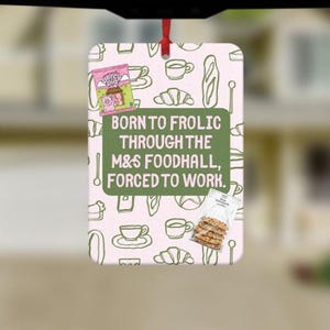 May include: A rectangular hanging air freshener with a light pink background featuring a repeating pattern of food icons. A central green box contains the text: BORN TO FROLIC THROUGH THE M&S FOODHALL, FORCED TO WORK. Includes images of Percy Pig sweets and biscuits.