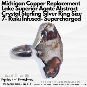 May include: A sterling silver ring with a Lake Superior agate stone set in a copper-colored band. The ring is size 7 and is infused with Reiki energy. The agate stone is abstract and has a white, brown, and red color pattern. The ring is supercharged with Reiki energy.