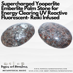 May include: Two gray and brown Yooperlite Emberlite palm stones. The stones are oval shaped and have a speckled appearance. The stones are described as "Supercharged Yooperlite Emberlite Palm Stone for Energy Clearing UV Reactive Fluorescent- Reiki Infused".