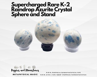 May include: Three blue and white K-2 Azurite crystal spheres on stands. The largest sphere is on a black stand, the other two are on clear stands. The spheres are supercharged and rare.  The text "Poppies and Moonstones" is at the bottom of the image.