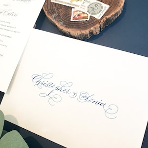 May include: A white envelope with the names "Christopher & Sonia" written in blue cursive script.