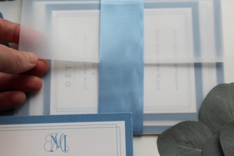 The vellum wrap adds such a touch of sophistication and softness along and also adds a protective functionality as well. Tie it all together with "something blue" in a wide light blue satin ribbon and you have a winning invitation every time.