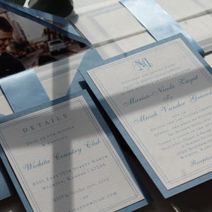 May include: Elegant wedding invitations in light blue and white. The invitations feature a photo, details, and names in a classic font. The design includes a monogram and the text "DETAILS" and "Wichita Country Club".