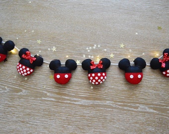 May include: A string of felt Mickey Mouse and Minnie Mouse characters with red and white polka dots, black ears, and red bows. The characters are strung together with white string and small white lights.