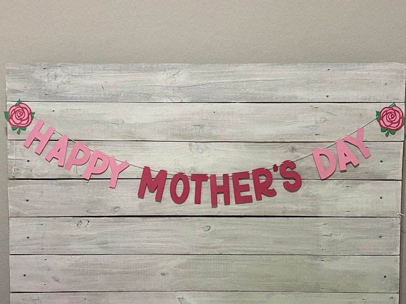 May include: Pink and red paper banner with the words "Happy Mother's Day" and pink roses on each end.