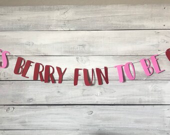 May include: A pink and burgundy paper banner that reads "It's Berry Fun To Be One".