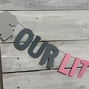 May include: A gray elephant cutout with a pink and gray banner that reads "OUR LITTLE".