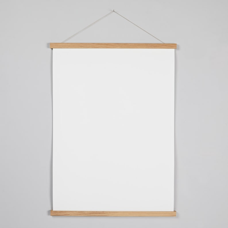 May include: A white poster hanging on a light gray wall in a wooden frame with a string attached to the top.