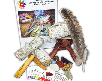 May include: A white sage smudging kit with a guidebook, a feather, a wooden stand, and seven chakra stones. The guidebook is titled "Chakra Healing Smudging and Cleansing Guide / Practices".