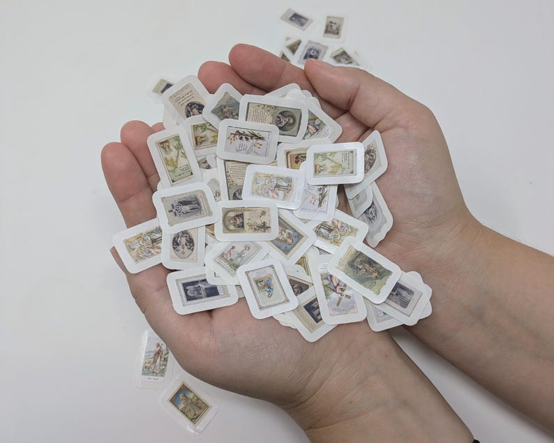 May include: A collection of small, rectangular stickers with vintage illustrations, held in open hands. The stickers feature various images in muted tones, with white borders. The overall aesthetic is antique and nostalgic.