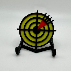 May include: A black and yellow target with a red arrow pointing to the centre, mounted on a black stand.