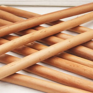 Peut inclure: Gros plan sur un tas de chevilles en bois brun naturel. Les chevilles sont lisses et ont une texture l&eacute;g&egrave;rement rugueuse.
