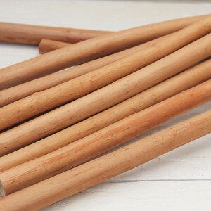 Peut inclure: Gros plan sur un tas de chevilles en bois naturel de couleur brun clair. Les chevilles sont lisses et ont une l&eacute;g&egrave;re teinte rouge&acirc;tre.