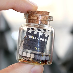 glass lucky charm, message vial, message in a bottle, curiosity cabinet, treasure, miniature world, papercraft, creases, cinema
