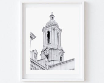May include: Black and white framed print of a tall, ornate clock tower. The tower features a domed top, columns, and two clock faces. The print is set against a white background.