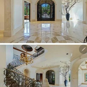 May include: A grand entrance to a home with a large, ornate iron gate and a marble floor. The floor is patterned with a checkerboard design. A large, bare tree branch in a vase sits in the corner of the room.