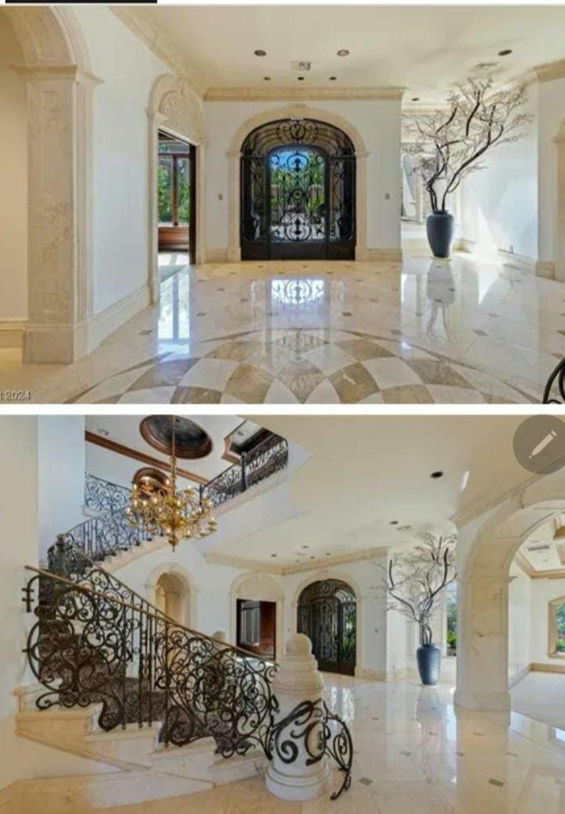May include: A grand entrance to a home with a large, ornate iron gate and a marble floor. The floor is patterned with a checkerboard design. A large, bare tree branch in a vase sits in the corner of the room.