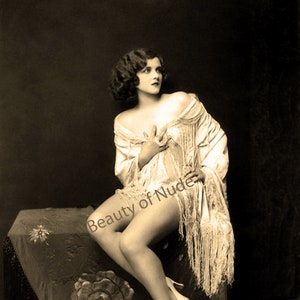 Halb angezogene Frau auf einem Pouf sitzend. Sinnliches Flapper Girl aus den 1920er Jahren
