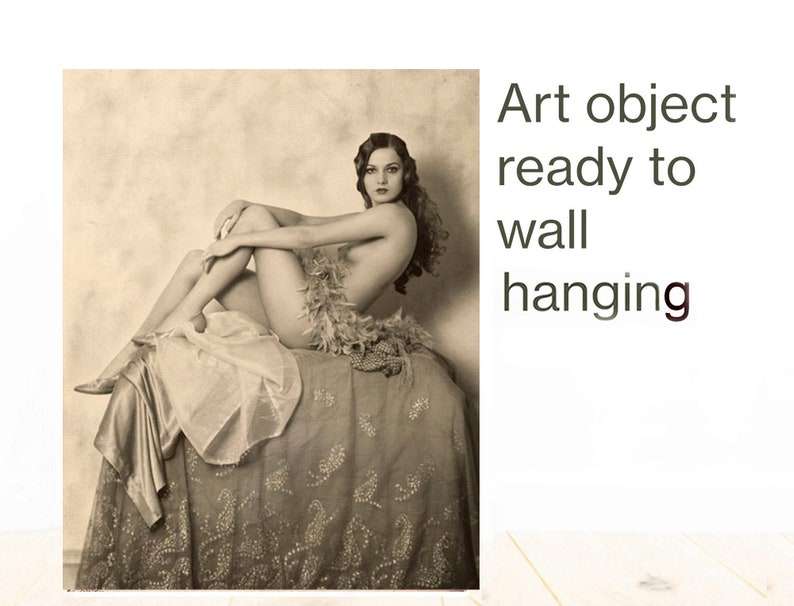 Puede incluir: Fotograf&iacute;a vintage en blanco y negro de una mujer sentada en una cama con un boa de plumas. La imagen est&aacute; lista para colgar en una pared.