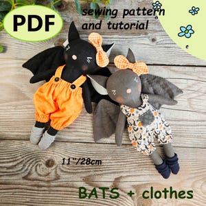 May include: Two handmade bat dolls with fabric wings and bows. One bat wears orange dungarees, the other a patterned jumpsuit. The dolls are approximately 28cm tall. The image includes the text "PDF sewing pattern and tutorial" and "BATS + clothes".