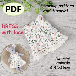 May include: A white dress with a floral pattern and lace trim, designed for mini animals. The dress is 6.4 inches (16 cm) long. The image includes the text "PDF", "DRESS with lace", "sewing pattern and tutorial", and "for mini animals".
