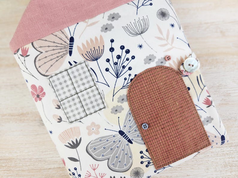 Close-up of fabric dollhouse door and window, decorative details of soft toy house