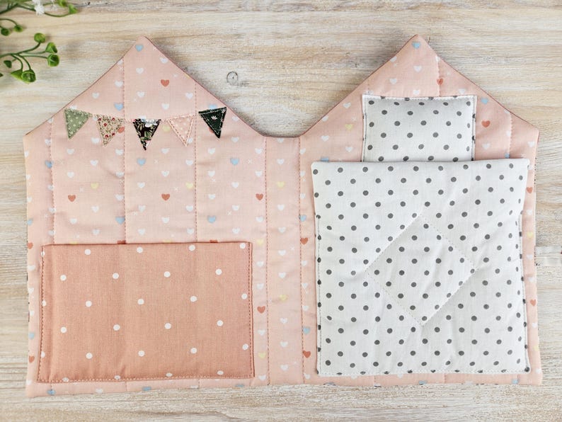 Inside view of fabric dollhouse sewing pattern, quilted doll bed and storage pockets for doll clothes