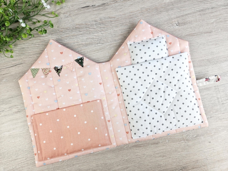 Close-up of quilted fabric dollhouse interior, bunting decoration and storage pocket