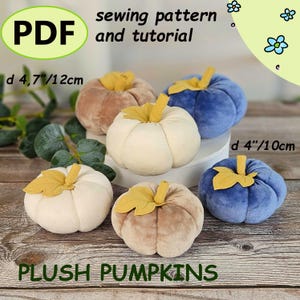 Peut inclure: Plusieurs citrouilles en peluche de couleurs crème, beige et bleu, avec des tiges et des feuilles jaunes. Les citrouilles mesurent environ 10 à 12 cm de diamètre. Le texte sur l'image indique "PDF sewing pattern and tutorial" et "PLUSH PUMPKINS."