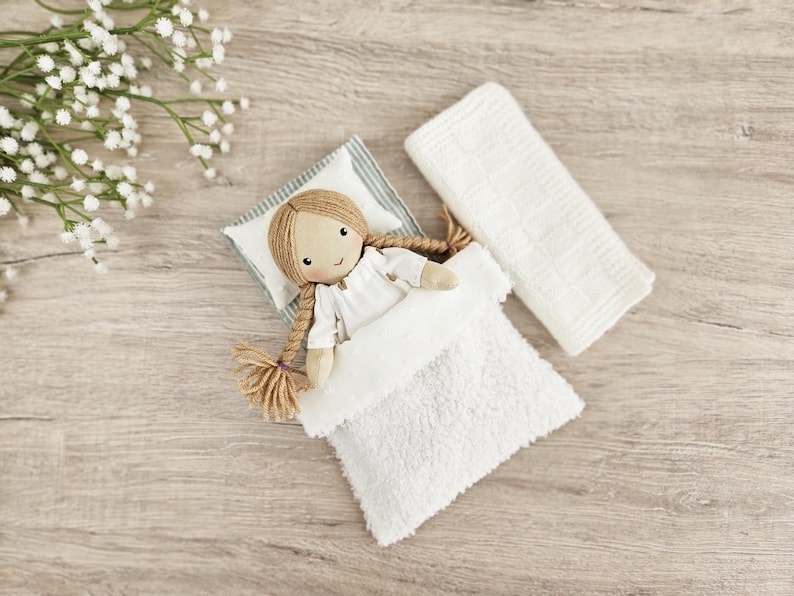 Handmade cloth doll in bed with miniature pillow and blanket, dollhouse bedding set