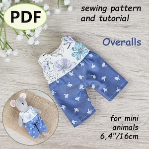 Op de afbeelding: Een PDF-naaipatroon en tutorial voor mini-dierenoveralls. De overall is blauw met een witte bloemen top en een blauw bloemenpatroon op de shorts. De afbeelding toont ook een kleine knuffelmuis die de overall draagt. De overall is 16 cm lang.