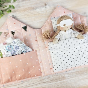 Opened fabric dollhouse interior, doll bedding and pockets for doll outfits, sewing pattern example