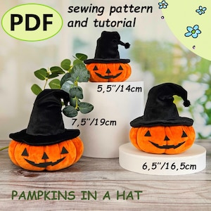 Puede incluir: Tres calabazas naranjas de peluche con caras sonrientes de jack-o'-lantern, cada una con un sombrero de bruja negro. Las calabazas miden 14 cm, 19 cm y 16,5 cm de diámetro. La imagen incluye el texto "PDF sewing pattern and tutorial" y "PAMPKINS IN A HAT."