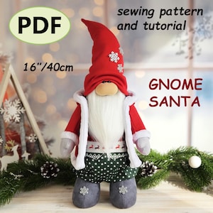 Puede incluir: Una muñeca Gnome Santa hecha a mano, de aproximadamente 40 cm de altura. La muñeca presenta un gorro rojo con detalles de copo de nieve, una larga barba blanca y un abrigo rojo con ribete blanco. Los pantalones de la muñeca son verdes con patrones de estrellas blancas. El texto "PDF" y "Gnome Santa" son visibles.