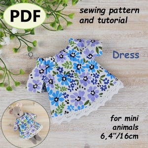 May include: A miniature dress with a floral pattern in blue, purple, and green, trimmed with white lace. The dress is designed for mini animals and measures 6.4 inches or 16 cm. The image includes the text "PDF sewing pattern and tutorial" and "Dress".
