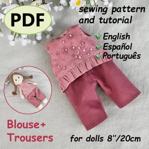 Puede incluir: Un patrón de costura PDF y un tutorial para ropa de muñecas. La imagen muestra un conjunto de blusa y pantalón rosa, con bordado floral y dobladillo con volantes. El texto indica que el patrón es para muñecas de 20 cm. El patrón está disponible en inglés, español y portugués.