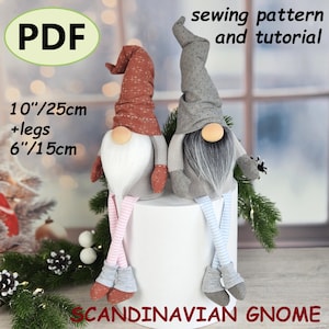 May include: Two Scandinavian gnome dolls, one with a red hat and the other with a grey hat. The dolls are approximately 25 cm tall, with 15 cm legs. The image includes the text "PDF", "sewing pattern and tutorial", and "Scandinavian Gnome".