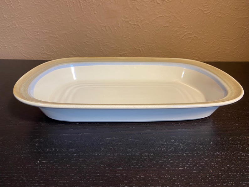 May include: A set of three ceramic mugs with a speckled, matte finish. The mugs are in shades of cream, light gray, and dark gray. Each mug has a simple, minimalist design, perfect for coffee or tea.