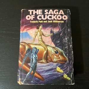 May include: Vintage paperback book titled "The Saga of Cuckoo" by Frederik Pohl and Jack Williamson. The cover art features a nude figure riding a golden creature, a winged statue, and butterflies against a colourful sky.