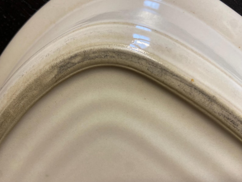 May include: A white ceramic mug with a black handle and the text "But First, Coffee" in a bold, black font. The mug is set against a neutral background, highlighting its simple design.