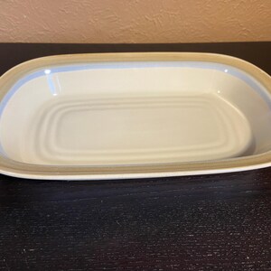 May include: A set of three ceramic mugs with a speckled, matte finish. The mugs are in shades of cream, light gray, and dark gray. Each mug has a simple, minimalist design, perfect for coffee or tea.